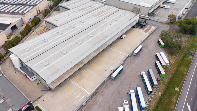 Sesto Ulteriano, Lombardy, Italy - 25 September 2026: Aerial view of the San Carlo Nord Italia Terminal, showing a large industrial warehouse with loading docks and parked trucks.