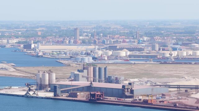 Aerial drone view of the seaport in Dunkirk, France. Industrial docks, cargo terminals, and commercial ships near the coastline.