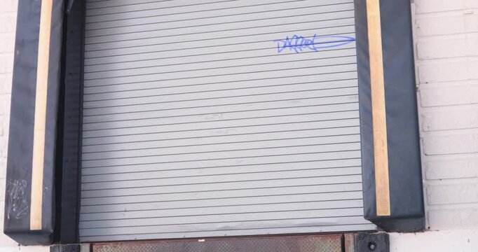 Industrial loading dock bay doors closed with black rubber cushion seals