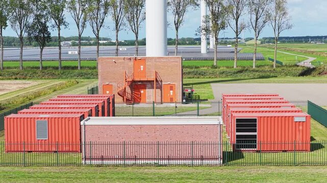 Aerial drone view of a battery energy storage system facility. Containers BESS units with transformers in a modern power grid station.