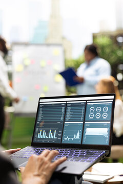 Business analytics, laptop and dashboard display charts as professional reviews performance figures. Planning, reporting and decision making support a data driven workshop in an urban garden.