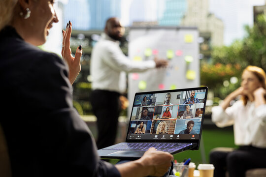 Video conference, laptop and businesswoman as professional greets online colleagues beside team workshop. Hybrid work, communication and collaboration link remote participants with outdoor meeting.