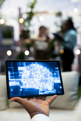 Artificial intelligence, tablet and digital brain graphic appear on handheld screen in foreground focus. Machine learning, innovation and analytics convey technology concepts in rooftop workspace. © DC Studio