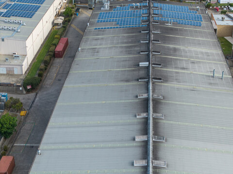 Melbourne, Australia - 06 October 2026: Aerial view of industrial factory rooftops featuring solar panel arrays and skylights in the Knox and Bayswater area.