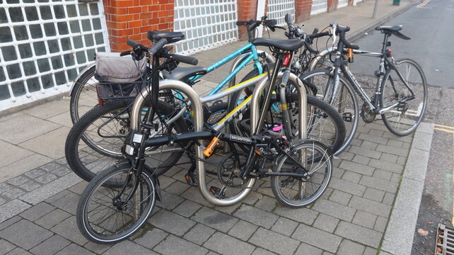 NORWICH, NORFOLK, ENGLAND - SEPTEMBER 2, 2026: Multiple bicycles parked on a sidewalk in front of a brick building