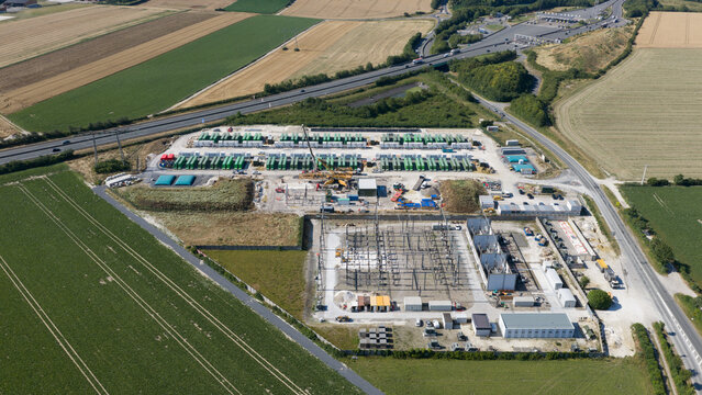 Saleux, Hauts-de-France, France - 08 July 2026: Aerial view of a large battery energy storage system facility surrounded by agricultural fields and a highway.