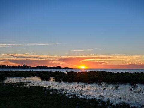 Sun setting on the sea horizon above the wetland, Touqian River estuary, Hsinchu, Taiwan