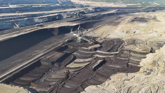 Bucket-wheel excavator with its cutting wheel, crawler units and conveyor system beside an exposed lignite face at Hambach mine, North Rhine-Westphalia, Germany.