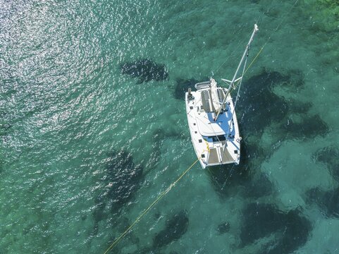Sailing catamaran from above, aerial view, turquoise water, Greece