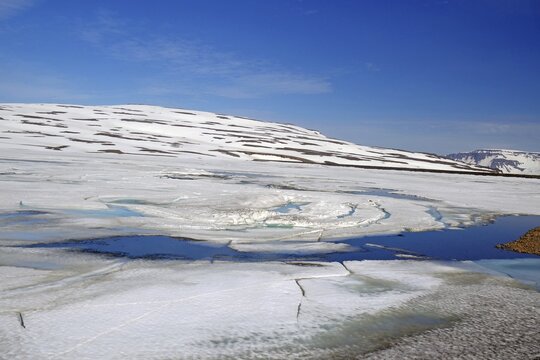 Lakes covered in ice that slowly breaks, snow, spring in the highlands, Fjadarheidi, Egilsstadir, Iceland