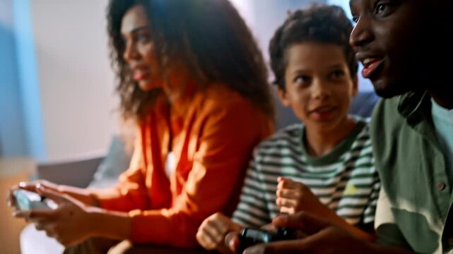 Parents son playing video games living room. Family holding controllers sofa.