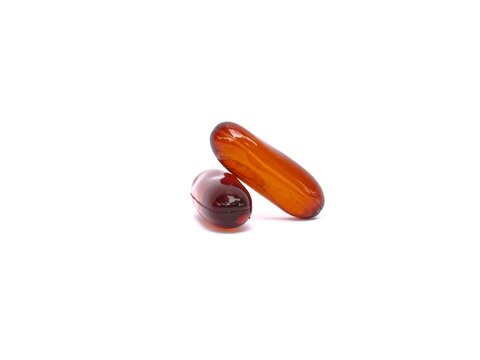Two fish oil softgels&mdash;health supplements containing omega-3, 6, and 9, vitamin E, or lecithin&mdash;are photographed against a white background.