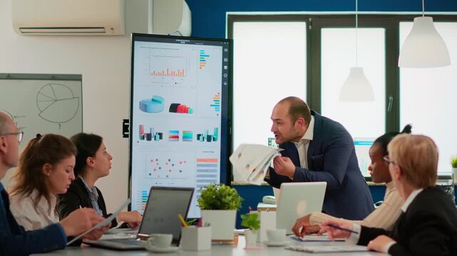 Conflict, frustration and businessman reacting during a tense office meeting, throwing documents as colleagues face workplace disagreement, poor results, pressure and communication breakdown.