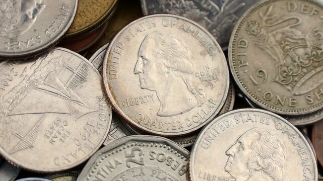 Many various coins of different countries circle rotation close up
