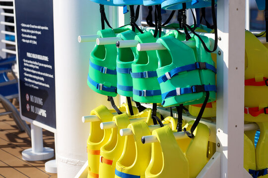 Children's Life Jackets on a Storage Rack by a Swimming Pool.