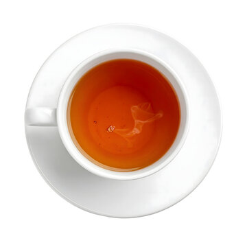 Tea cup filled with warm brown herbal drink served in white ceramic saucer isolated view from above on transparent background