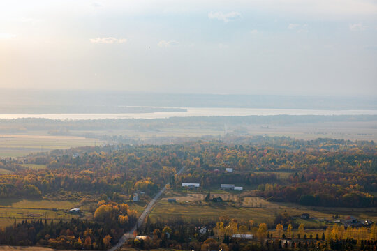 Autumn landscape of rural autumn forest and farmland under hazy sky. Champlain Lookout in Gatineau Park, Canada.