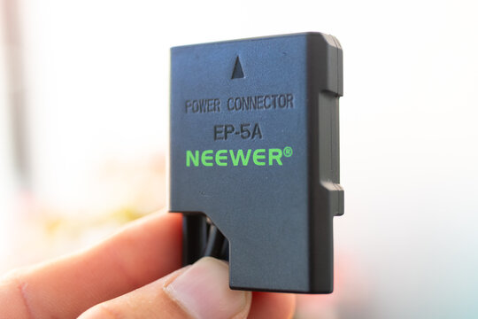 ZAPOPAN, MEXICO - OCTOBER 14, 2026: Neewer EP-5A dummy battery power adapter held in hand.