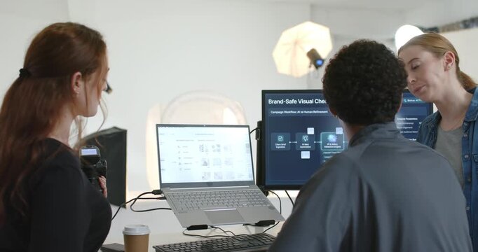 Diverse team reviewing Brand-Safe Check visuals on right monitor at studio desk with DSLR