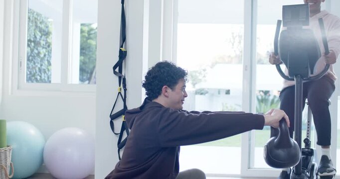 African American training duo trainer coaching trainee lowering kettlebell squat at home