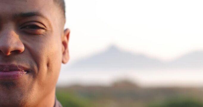 African American man shifting from neutral to laugh outdoors with sunlit brush and ridge