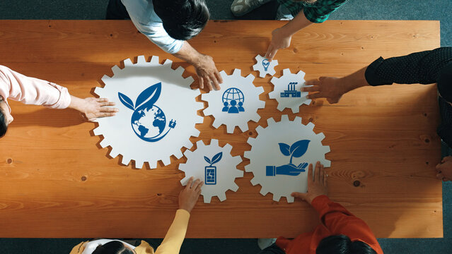 Collaborative Efforts in Business Sustainability with Eco-Friendly Icons and Concepts on a Wooden Table in a Professional Setting. Amity