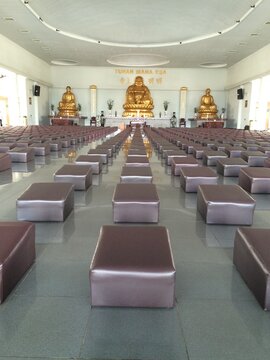 Spacious Temple Hall with Rows of Seating Cushions and Buddha Statues in Batam