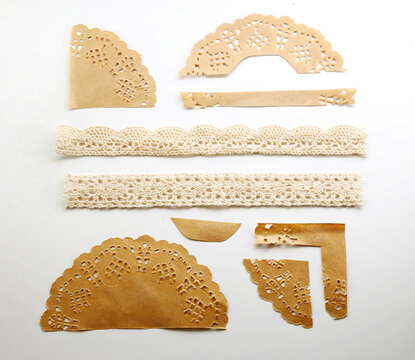 Assorted beige paper lace cutouts and ornamental borders for vintage crafts and invitations.