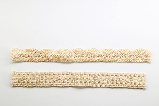 Cream paper lace borders with delicate scalloped edges isolated on a clean white background.