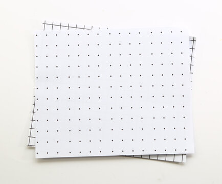 Blank white dotted paper sheets arranged in layers for minimalist stationery, notes and creative planning.