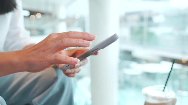 Woman using smartphone and eating snack at modern city cafe, urban lifestyle, mobile browsing, social media, online communication and relaxing coffee break during leisure time in busy city environment