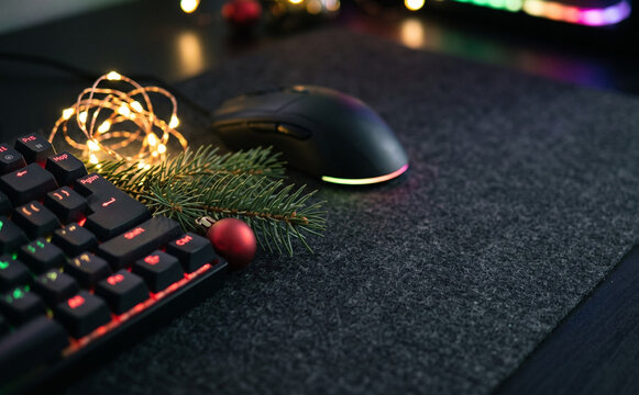 Festive gaming desk setup with Christmas lights, keyboard, and mouse for holiday season