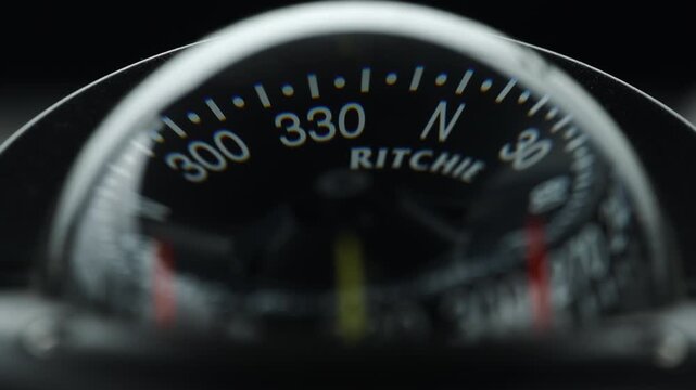 Detailed closeup of marine compass showing degree markings and north heading inside a boat