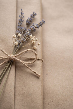 Rustic gift package wrapped in brown craft paper decorated with dried lavender and twine bow