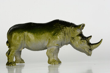 A greyish-green plastic rhinoceros toy with a horn © Rusli