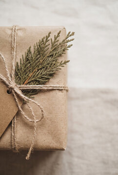 Rustic wrapped Christmas gift box with twine and evergreen branch for holiday present design