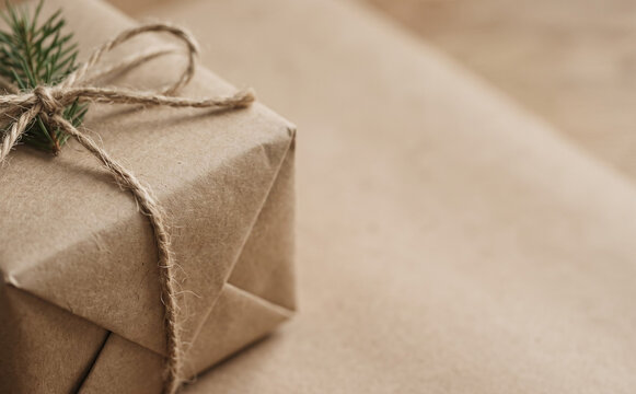 Eco friendly wrapped gift box with twine and pine sprig for holiday present background