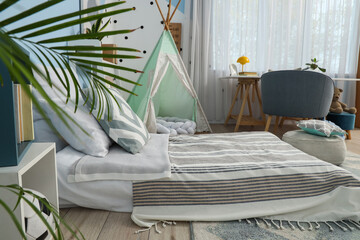 Childhood development and nursery interior, cozy bedroom with teepee tent and floor bed for toddler play and rest in a modern family home environment © Pixel-Shot