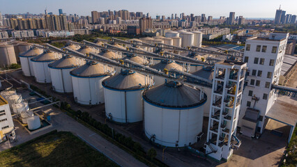 Large white grain storage silos in an urban industrial zone © Zhaorui