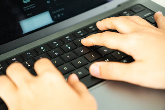 Hands Typing on a Computer Keyboard From Side View