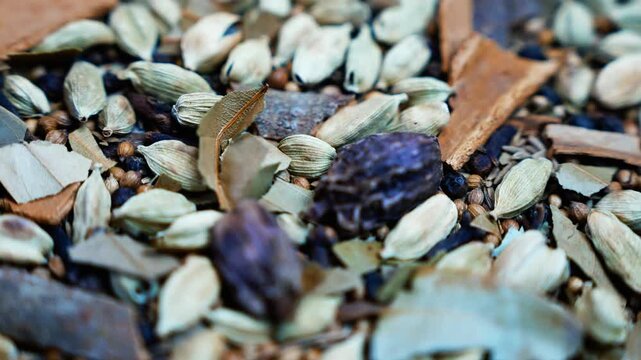 Close-up of dried cardamom and botanical spices, Close-up of assorted dried cardamom pods, cinnamon bark, leaves and dark botanicals arranged as a natural spice and potpourri texture.