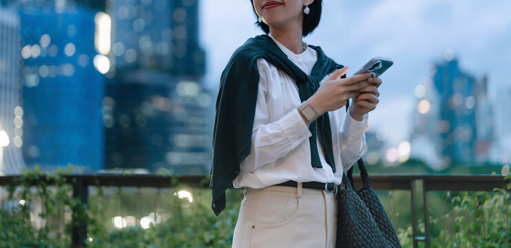 Business asian woman relax using smartphone social network communication metropolis city building background