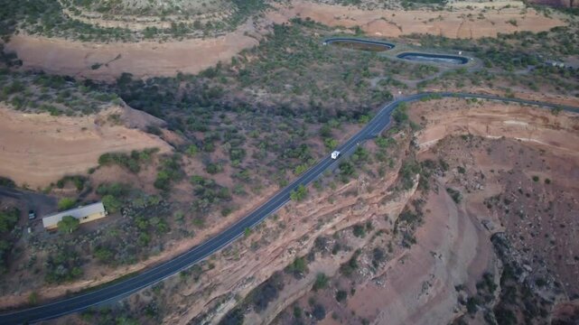 Aerial view of switchback road curving around sandstone canyon