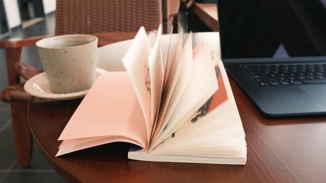 Open book and coffee on wooden table, modern caf&eacute; interior, Tokyo, Japan