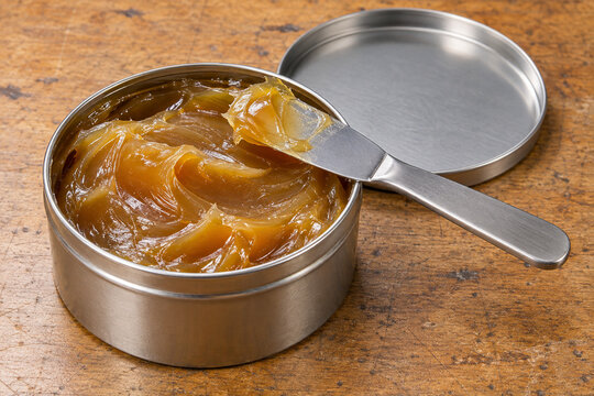 Amber Machinery Grease in an Open Tin with a Metal Spatula
