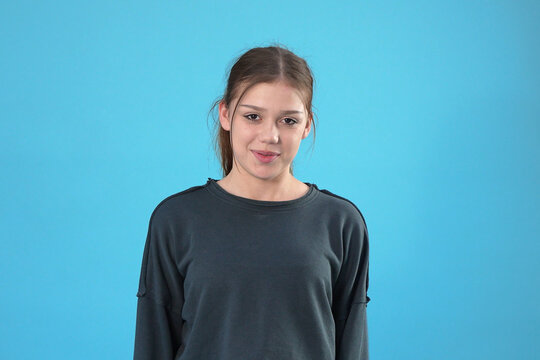 Portrait of a smiling young woman against a blue background