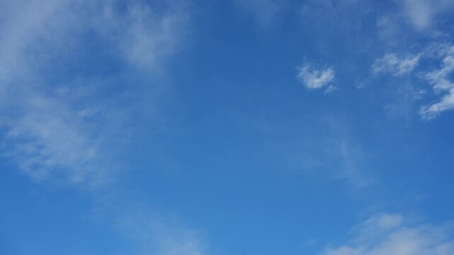 A peaceful sky timelapse showcases thin cirrus clouds and delicate cirrostratus patches dissolving across a deep blue atmosphere, revealing shifting cloud textures shaped by gentle upper winds. 4k.
