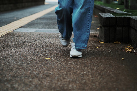 雨上がりの歩道を歩く足元のクローズアップ