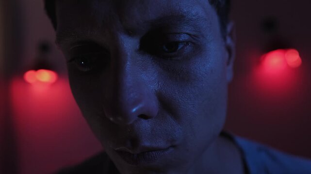 Anxious man in an intimate wide angle close up looking around with quiet panic and growing suspense, creating a feeling of psychological unease and approaching danger