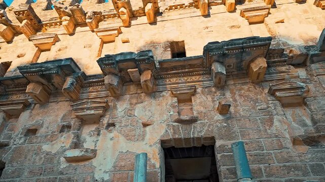 Aspendos, Antalya reveals intricate stone details of the ancient Roman theater stage building through a smooth left to right panning camera movement.